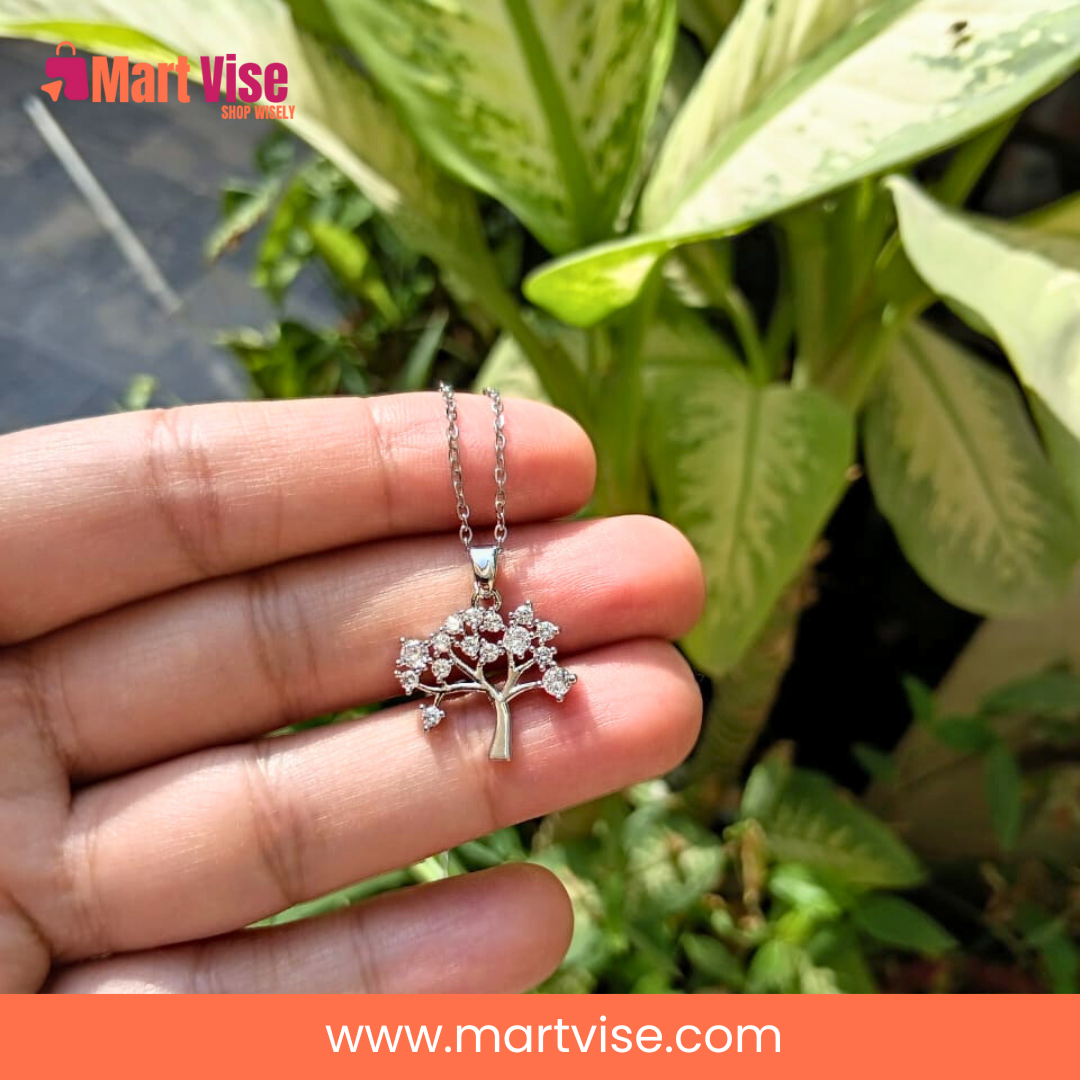 stainless-steel-tree-necklace-display.jpg – Stainless steel tree necklace displayed on light wood surface.